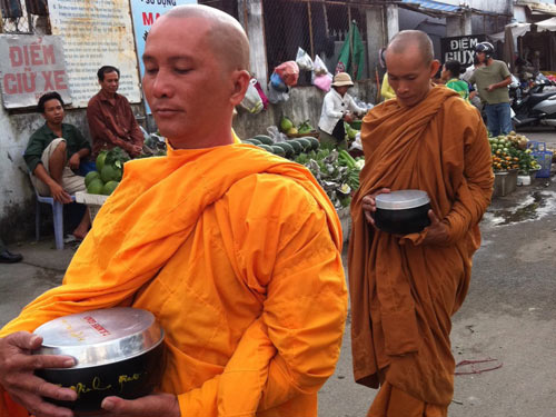 Giả sư ôm bình bát đứng trước cửa chùa 